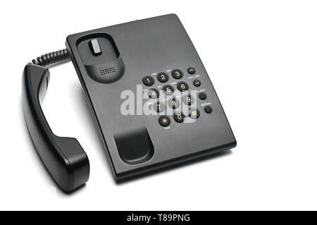 Classico telefono cablato utilizzati a casa e negli uffici su un isolato bianco sfondo.Sollevare il ricevitore del telefono Foto Stock