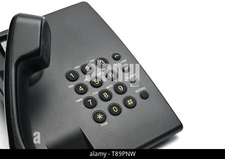 Classico telefono cablato utilizzati a casa e negli uffici su un isolato bianco sfondo.Sollevare il ricevitore del telefono Foto Stock