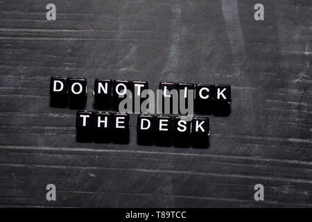 Non leccare la scrivania su blocchi di legno. Istruzione, ispirazione e motivazione concept Foto Stock