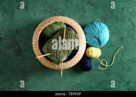 Recipiente di vimini con filato per maglieria su tavola Foto Stock