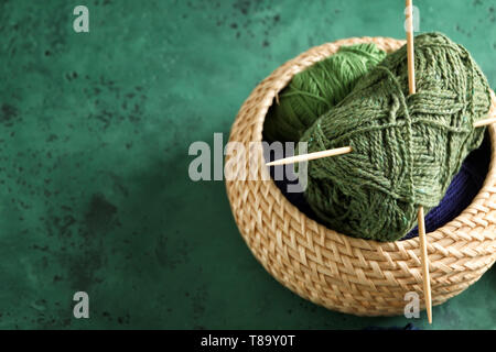 Recipiente di vimini con filato per maglieria su tavola Foto Stock