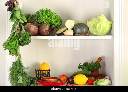 Diverse le erbe fresche con spezie e verdure sugli scaffali Foto Stock