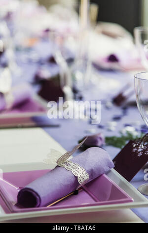Set di tabelle nella sala di ricevimento di un matrimonio con colore lilla decorazione Foto Stock