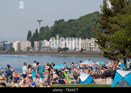 Seattle, Washington: persone folla Alki Beach in West Seattle come la città si affaccia record di calore per il secondo giorno consecutivo. Attraverso Elliott Bay è il punto di riferimento lo Space Needle. Foto Stock