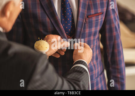 Seamster abito di sartoria per client maschio in atelier Foto Stock