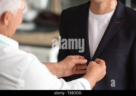 Seamster abito di sartoria per client maschio in atelier Foto Stock