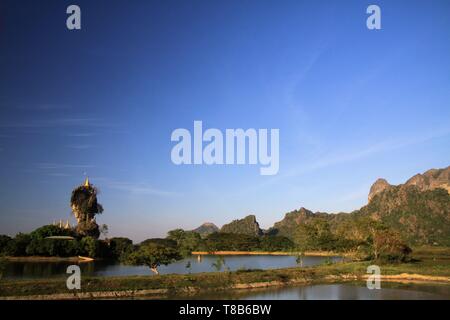 Vista su Kyauk Kalap pagoda situata su un alto edificio roccia isolata su un lago in Hpa Un, Myanmar Foto Stock