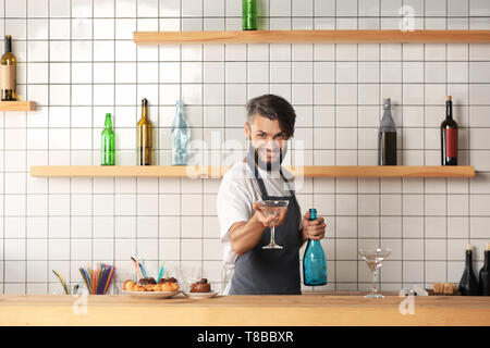 Bello il barista con bicchiere di cocktail in bar Foto Stock