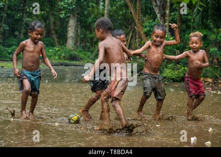 Papua Nuova Guinea, Milne Bay Provincia, Encastreaux Mare, Trobriands arcipelago, Kiriwina Isola, Okaiboma Village, bambini che giocano a calcio Foto Stock