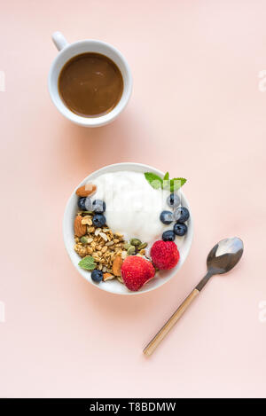 Muesli con yogurt e frutti di bosco per una sana prima colazione. Ciotola di yogurt greco con muesli, mandorle, mirtilli e fragole, vista dall'alto, copia dello spazio. Foto Stock