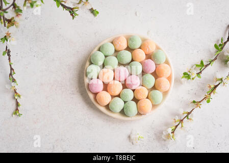 Mini Mochi - tradizionale giapponese del dessert su tavolo bianco, vista dall'alto, copia dello spazio. Foto Stock
