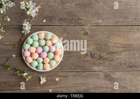 Mini Mochi - tradizionale giapponese del dessert su sfondo di legno, vista dall'alto, copia dello spazio. Foto Stock