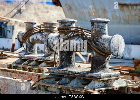 Grandi bitte in metallo con lo spooling funi di acciaio per ormeggio navi Foto Stock