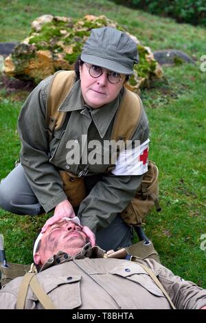 Francia, Eure, Sainte Colombe prÚs Vernon, Allied ricostituzione gruppo (US Guerra Mondiale 2 e macchia francese ricostruzione storica Associazione), il reenactor Nathalie Menager come infermiera dal 101st US Airborne Division prendersi cura di un soldato ferito Foto Stock