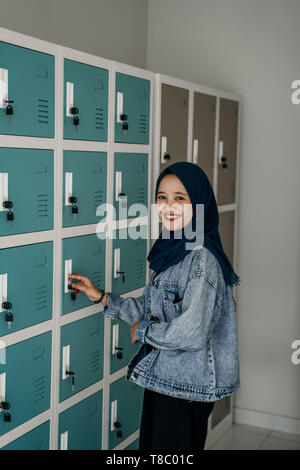 Musulmani asiatici studente femmina in spogliatoio Foto Stock