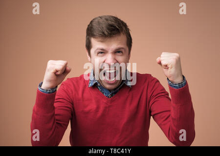 Uomo felice alzando le mani su essere felice ed entusiasta Foto Stock