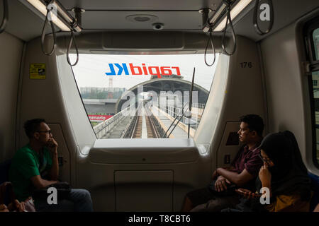 Passeggeri guardando attraverso la finestrella del driverless commuter train come unità in stazione Rrailway, tracce elevata e alla stazione di Kuala Lumpur in Malesia Foto Stock