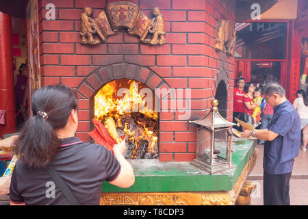 Cinese tradizionale Anno nuovo rituale della masterizzazione di replica di carta moneta e joss carta ,culto cinesi in un tempio, Kuala Lumpur, Malesia Foto Stock