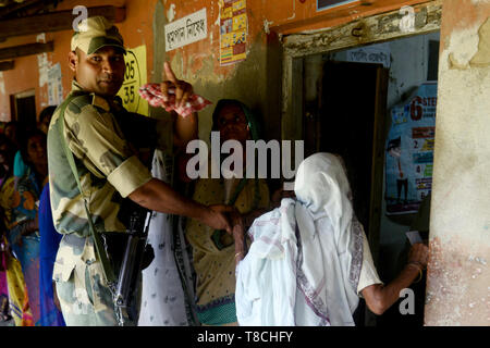 West Midnapore, India. Il 12 maggio 2019. Sicurezza aiuta la persona anziana donna durante la sesta fase di Lok Sabha elezione a Ghatal Lok Sabha circoscrizione nella West Midnapore. Credito: Saikat Paolo/Pacific Press/Alamy Live News Foto Stock