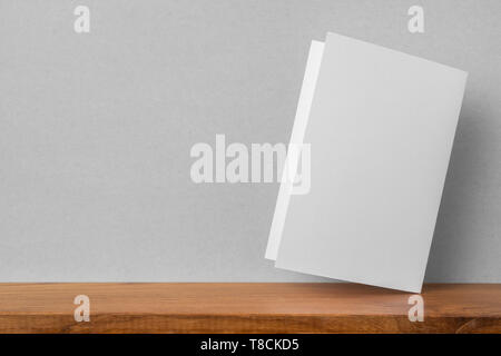 Concetto di Design - Vista frontale del biglietto di auguri su scaffale e muro grigio per mockup, non 3D render Foto Stock