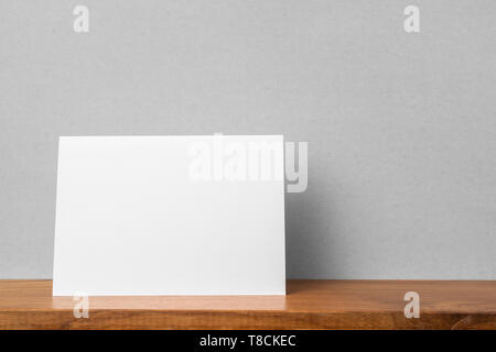 Concetto di Design - Vista frontale del biglietto di auguri su scaffale e muro grigio per mockup, non 3D render Foto Stock