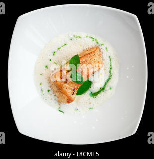 Brasato di filetto di pesce con salsa di schiuma ripresa dall'alto isolato su nero Foto Stock