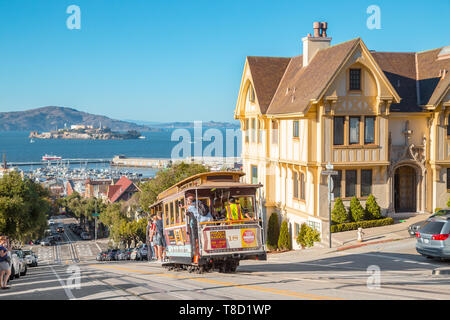 Settembre 25, 2016 - SAN FRANCISCO: Powell-Hyde Funivia salita ripida collina nel centro di San Francisco con la famosa Isola di Alcatraz in backgroun Foto Stock