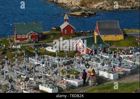 La Groenlandia, west coast, baia di Baffin, Upernavik, il cimitero, le bare sono collocati sulla superficie e poi ricoperto con pietre o cemento, la massa non può essere scavato le tombe sono poi decorate con fiori artificiali, la vecchia chiesa e il museo di edifici in background Foto Stock