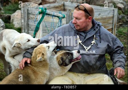 La Groenlandia, costa ovest, Uummannaq, lo Sled Dog allevatore Malti Suulutsun orso che indossa pantaloni di pelle Foto Stock