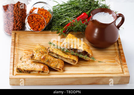 Khachapuri /Lobiani - cibo tradizionale georgiano/armeno - pane ripieno di fagioli rossi e servito con latte fermentato su una tavola di legno. Foto Stock