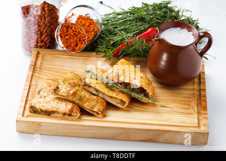 Khachapuri /Lobiani - cibo tradizionale georgiano/armeno - pane ripieno di fagioli rossi e servito con latte fermentato su una tavola di legno. Foto Stock