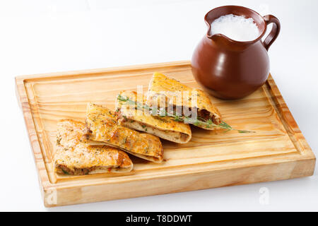 Khachapuri /Lobiani - cibo tradizionale georgiano/armeno - pane ripieno di fagioli rossi e servito con latte fermentato su una tavola di legno. Foto Stock