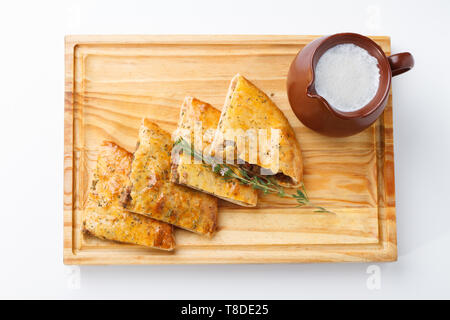 Khachapuri /Lobiani - cibo tradizionale georgiano/armeno - pane ripieno di fagioli rossi e servito con latte fermentato su una tavola di legno. Foto Stock