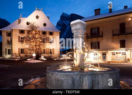 Francia, Haute Savoie, Massiccio del Chablais, Samoens, Gran Massiccio, il centro del villaggio di crepuscule fontana e la montagna di Criou Foto Stock