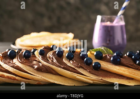 Deliziose frittelle sottili con bacche e pasta cioccolato sulla piastra, primo piano Foto Stock