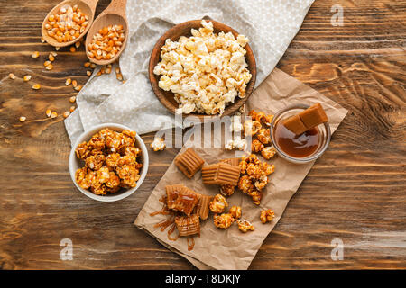 Composizione con deliziosi popcorn su sfondo di legno Foto Stock