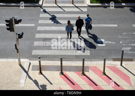Angolo di alta vista di tre persone o pedoni che attraversano attraversamento pedonale o Zebra Marsiglia Francia Foto Stock
