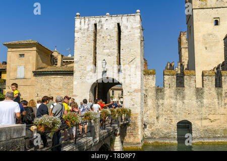 SIRMIONE SUL LAGO DI GARDA, Italia - Settembre 2018: persone attraversando un ponte per immettere la città vecchia e il Castello Scaligero. Si tratta di una fortezza medievale del lak Foto Stock