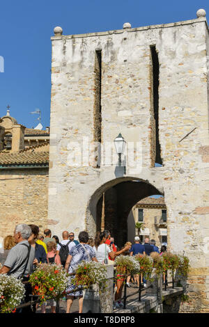 SIRMIONE SUL LAGO DI GARDA, Italia - Settembre 2018: persone attraversando un ponte per immettere la città vecchia e il Castello Scaligero. Si tratta di una fortezza medievale del lak Foto Stock