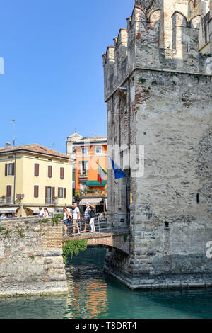 SIRMIONE SUL LAGO DI GARDA, Italia - Settembre 2018: persone attraversando il ponte sopra il fossato come provengono al di fuori del castello scaligero nel centro di Sirmione o Foto Stock