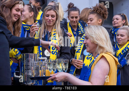 Schwerin, Germania. Il 12 maggio 2019. Il primo ministro di Mecklenburg-Vorpommern, Manuela Schwesig (r, SPD), distribuisce bicchieri di champagne per i giocatori di pallavolo della SSC Palmberg Schwerin in occasione di un ricevimento a fronte della Cancelleria dello Stato. Il CSD Palmberg Schwerin perso su 11.05.2019 dopo cinque round finale dell'ultimo gioco per il terzo campione tedesco in un titolo in fila. Credito: Jens Büttner/dpa-Zentralbild/dpa/Alamy Live News Foto Stock