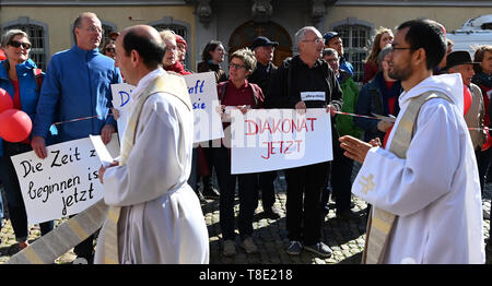 Freiburg, Germania. Il 12 maggio 2019. I sacerdoti a piedi passato i partecipanti ad un'azione di protesta dell'iniziativa Maria 2.0 di donne cattoliche della comunità di nell Arcidiocesi di Friburgo. Un banner che dice "iaconate ora' circa 400 donne hanno invitato la Chiesa a ripensare e a promuovere la giustizia di genere in una azione di protesta. Credito: Patrick Seeger/dpa/Alamy Live News Foto Stock