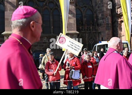 Freiburg, Germania. Il 12 maggio 2019. I sacerdoti a piedi passato i partecipanti ad un'azione di protesta dell'iniziativa Maria 2.0 di donne cattoliche della comunità di nell Arcidiocesi di Friburgo. Un poster dice, "perché solo gli uomini essere chiamato?' circa 400 donne hanno invitato la Chiesa a ripensare e a promuovere la giustizia di genere in una azione di protesta. Credito: Patrick Seeger/dpa/Alamy Live News Foto Stock
