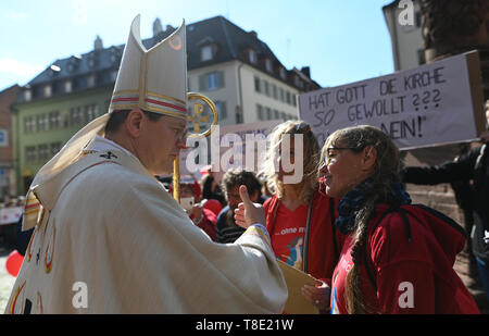 Freiburg, Germania. Il 12 maggio 2019. L'Arcivescovo di Friburgo, Stephan Burger (l), parla alle donne di Maria 2.0 iniziativa delle donne cattoliche della comunità di nell Arcidiocesi di Freiburg davanti alla cattedrale. Circa 400 donne hanno invitato la Chiesa a ripensare e a promuovere la giustizia di genere in una azione di protesta. Credito: Patrick Seeger/dpa/Alamy Live News Foto Stock