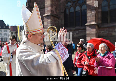 Freiburg, Germania. Il 12 maggio 2019. L Arcivescovo Stephan Burger passa le donne di Maria 2.0 iniziativa delle donne cattoliche della comunità di nell Arcidiocesi di Freiburg davanti alla cattedrale. Le donne detengono diversi banner nell'aria. Circa 400 donne hanno invitato la Chiesa a ripensare e a promuovere la giustizia di genere in una azione di protesta. Credito: Patrick Seeger/dpa/Alamy Live News Foto Stock