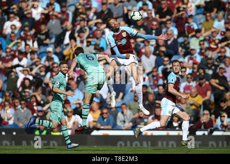 Burnley, Regno Unito. Il 12 maggio 2019. Peter Crouch di Burnley salta al di sopra di Laurent Koscielny di Arsenal e capi la palla. Premier League, Burnley v Arsenal a Turf Moor a Burnley, Lancashire domenica 12 maggio 2019. Questa immagine può essere utilizzata solo per scopi editoriali. Solo uso editoriale, è richiesta una licenza per uso commerciale. Nessun uso in scommesse, giochi o un singolo giocatore/club/league pubblicazioni. Credito: Andrew Orchard fotografia sportiva/Alamy Live News Foto Stock