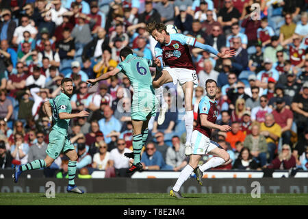 Burnley, Regno Unito. Il 12 maggio 2019. Peter Crouch di Burnley salta al di sopra di Laurent Koscielny di Arsenal e capi la palla. Premier League, Burnley v Arsenal a Turf Moor a Burnley, Lancashire domenica 12 maggio 2019. Questa immagine può essere utilizzata solo per scopi editoriali. Solo uso editoriale, è richiesta una licenza per uso commerciale. Nessun uso in scommesse, giochi o un singolo giocatore/club/league pubblicazioni. Credito: Andrew Orchard fotografia sportiva/Alamy Live News Foto Stock