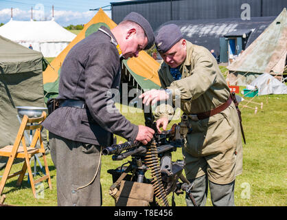 Il Museo del Volo, East Fortune, East Lothian, Scozia, Regno Unito il 12 maggio 2019. Esperienza di guerra: una giornata con la famiglia con tutte le cose relative al mondo di guerre tra cui una replica di una seconda guerra mondiale esercito tedesco camp e attrezzature militari,. Uomini vestiti in tedesco uniforme militare con una mitragliatrice Foto Stock