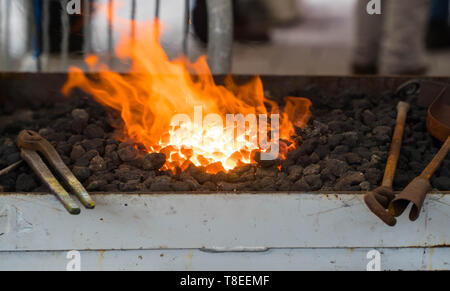 Il maniscalco forno con carboni ardenti e attrezzi di formatura Foto Stock