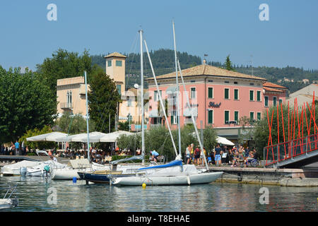 I turisti a piedi sulla passeggiata costiera di Bardolino sulle rive del Lago di Garda - Italia. Foto Stock